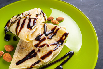 crepes with banana and chocolate spread on a green plate