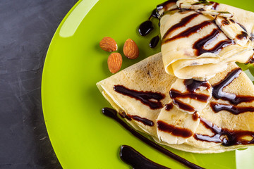 crepes with banana and chocolate spread on a green plate