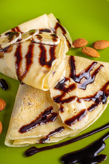 crepes with banana and chocolate spread on a green plate