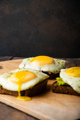 delicious sandwich with avocado and egg on a wooden stand