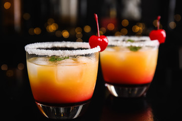 Fresh alcoholic Tequila Sunrise cocktails on black table
