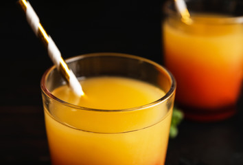 Fresh alcoholic Tequila Sunrise cocktail on dark background, closeup
