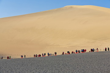 Fototapeta na wymiar Sled-riders on the dunes around Crescent lake-Yueyaquan oasis. Dunhuang-Gansu-China-0661