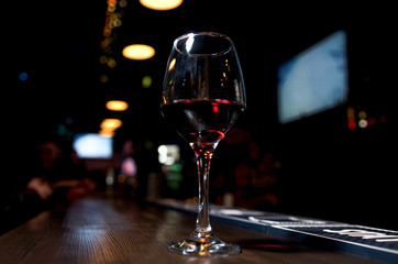 Glass of red wine on backlighted background