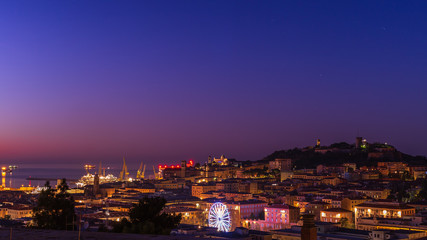 Fototapeta na wymiar Panorama del centro della città di Ancona al tramonto, sotto le feste di Natale, con la ruota panoramica e il Duomo di San Ciriaco