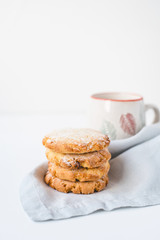 Stacked cookies on a linen napkin and a cup of coffee.