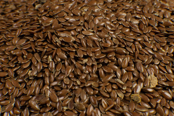 Linum usitatissimum is scientific name of Brown Flax seed. Also known as Linseed, Flaxseed and Common Flax. Closeup of grains, background.