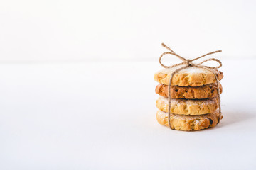 Stack of fresh cookies on white wooden table.