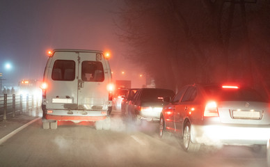 Traffic jam on the road in the fog at night
