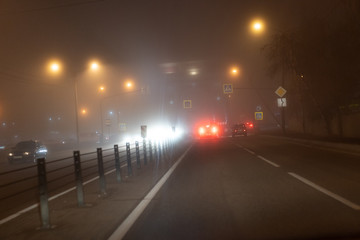Cars ride in the fog at night