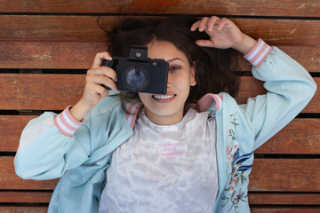 Joven mujer fotografa en el parque fotografiando con su camara reflex antigua