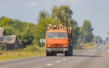 Timber truck with a forest rides on the highway with cargo