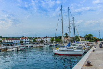 Fototapeta na wymiar Njivice, Croatia / 22nd June 2019: Boats in harbour in colorful town Njivice, Krk island, Croatia