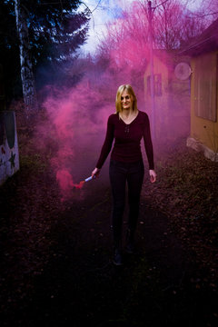 Fotoshooting mit einer jungen h&uuml;bschen Frau und einer Rauchbombe - Farbbombe - smokebomb - rosa Nebel