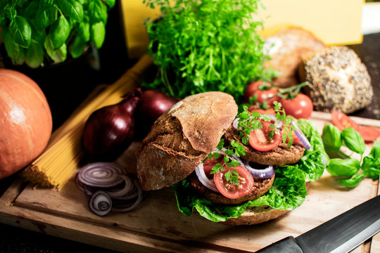 vegetarischer Bio Burger im Roggen Brötchen mit Tomaten und Zwiebeln