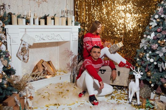 Lovely young couple beautiful woman and handsome man in cozy warm sweaters for celebrating the new year christmas festive mood. Merry Christmas, Christmas decor. The atmosphere of the holidays