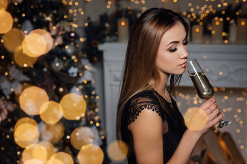 Beautiful girl with glass of champagne celebrating. Portrait of smiling young woman with blonde hair, stylish hairstyle, sexy glamour makeup on beauty face with drink.