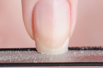 Close up photo of woman doing manicure with nail file
