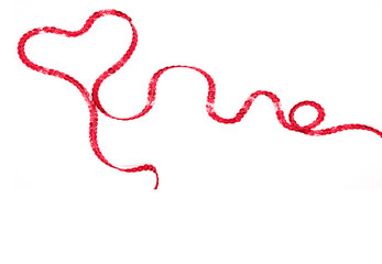 Heart made of red sequin ribbon on a white background