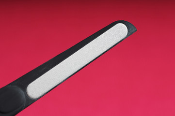 black metal lazer nail file manicure on bright pink background