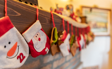 Calze di Natale con Babbo Natale appese sul caminetto per festeggiare l'arrivo del Natale in famiglia, dove mettere i doni e i dolciumi e cioccolatini
