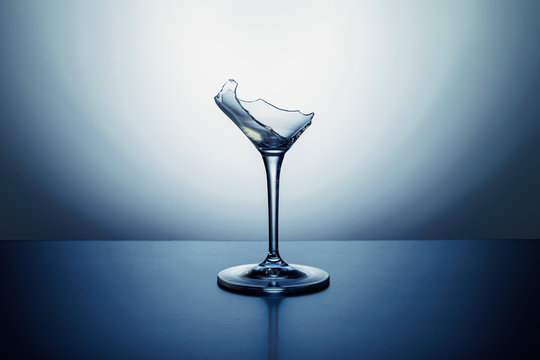 broken wineglass on the table with colored background
