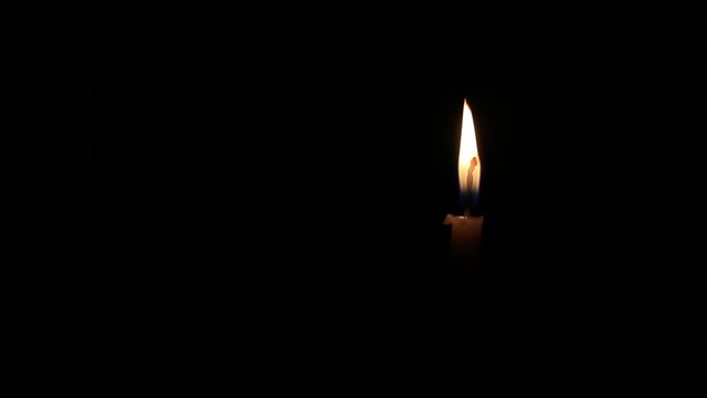 Burning candle isolated on black background with space for text. Concept of mourning, sadness, sorrow. Commemoration day.