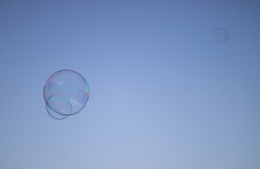 Fototapeta na wymiar Seifenblase vor wolkenlosem Himmel