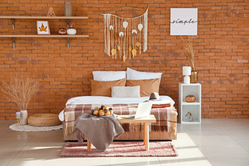 Fototapeta na wymiar Stylish interior of modern bedroom with autumn decor