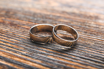 Pair of wedding rings on wooden background