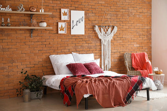 Stylish interior of modern bedroom with autumn decor