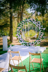 Wedding ceremony. Floral wedding decor in the park. American wedding. Chairs, arch and flowers for a wedding ceremony in a park