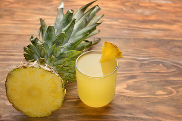 Fresh cut pineapple and juice on wooden background