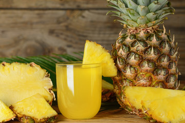 Composition with fresh ripe pineapples and juice on wooden background