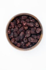 Dried Red Jujube Fruit (Dried Red Dates) in wooden bowl on white background