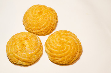 Three delicious round cookies lie on a white background in the shape of a triangle. Selective focus.