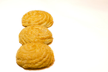 Three delicious round cookies lie on a white background in a row. Selective focus.