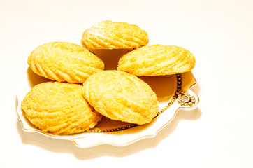 Five delicious cookies lie on a white porcelain plate on a white background.Close up. Selective focus.