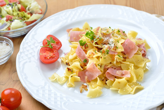 Deftige &ouml;sterreichische K&uuml;che: Schinkenfleckerln mit den typischen Fleckerlnudeln, dazu ein kleiner Salat mit Steirischem Kern&ouml;l - Austrian cuisine: Special ham pasta  and a side salad with Styrian pu