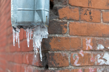 Tver. Quarter of old houses. Morozov barracks in winter. Frozen storm sewer pipe.