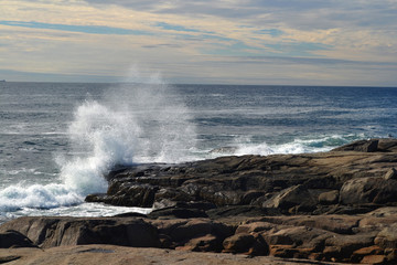 Brechende Wellen an der Küste Neu Englands vor Sommerhimmel / Waves at the coast of new england