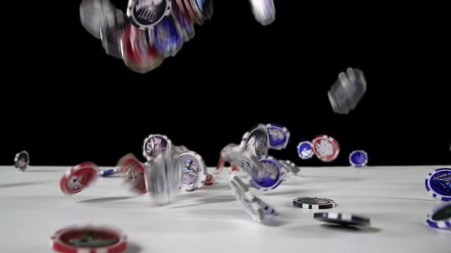 Close-up view in perspective: Pocker chips falling down on the white table