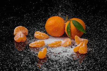 Fototapeta na wymiar Tangerines mandarines with water drops on black background. New Year 2020