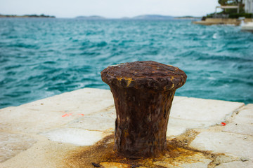 Tribunj, Croatia / 18th May 2019: Pier and old rust Dock Bollard