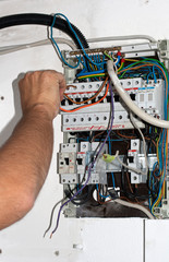 Electrician work connecting cables at switchbox