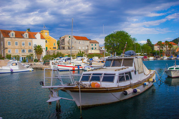 Fototapeta na wymiar Zlarin, Croatia / 18th May 2019: Seafront view on Zlarin, boats, harbour, Church of Holy Mary