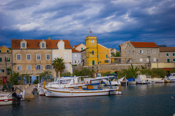 Zlarin, Croatia / 18th May 2019: Seafront view on Zlarin, boats, harbour, Church of Holy Mary