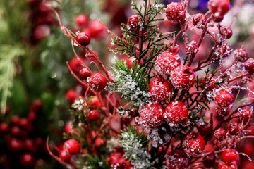 Arrangement of Christmas berry holly or ilex twigs, red balls as a home decorations for the Christmas New Year holidays.