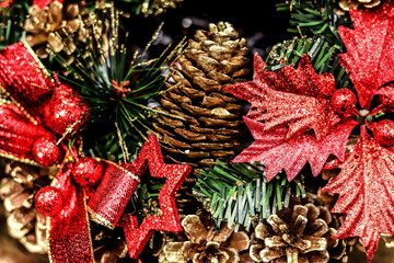 New Year and Christmas decor background of cones, winter berries, spruce branches, toys and burning candles.