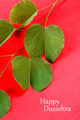 Indian Festival Dussehra, showing golden leaf on red background. Greeting card.